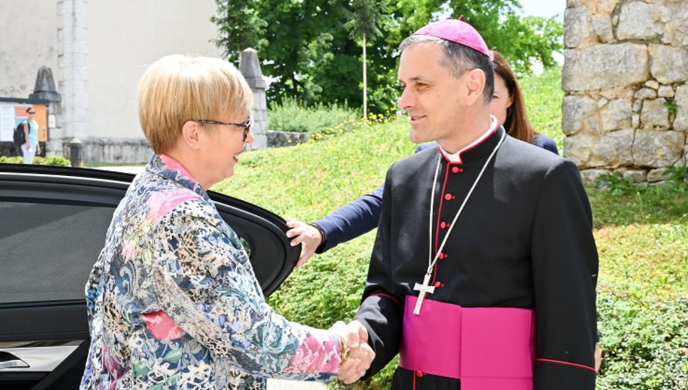 Staatspräsidentin Natasa Pirc Musar und Bischof Andrej Saje schütteln einander die Hände 