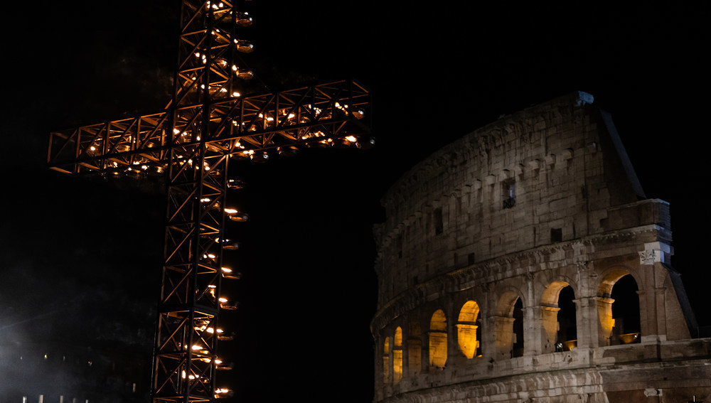 Blick auf das beleuchtete Kreuz mit entzündeten Lichtern vor dem Kolosseum an Karfreitag in Rom