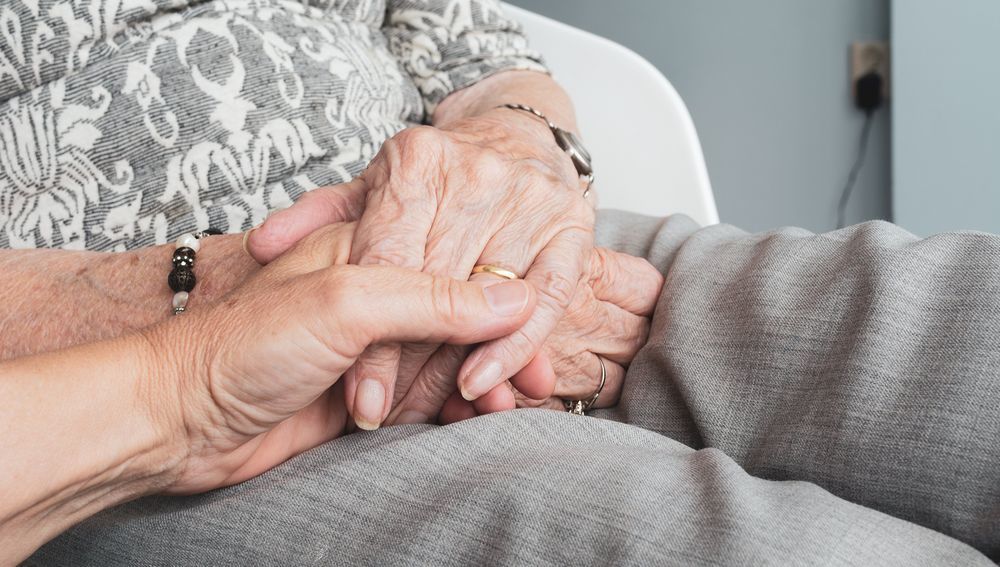 Hand hält die einer Seniorin