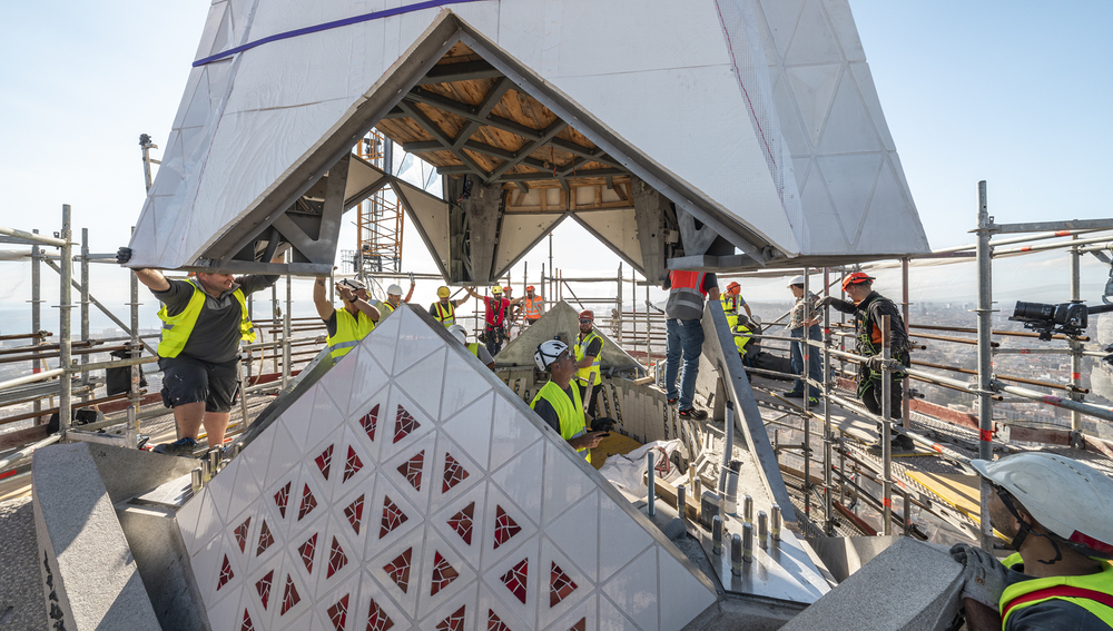 Bauarbeiter montieren erstes Element von Kreuz auf Christusturm der Sagrada Família