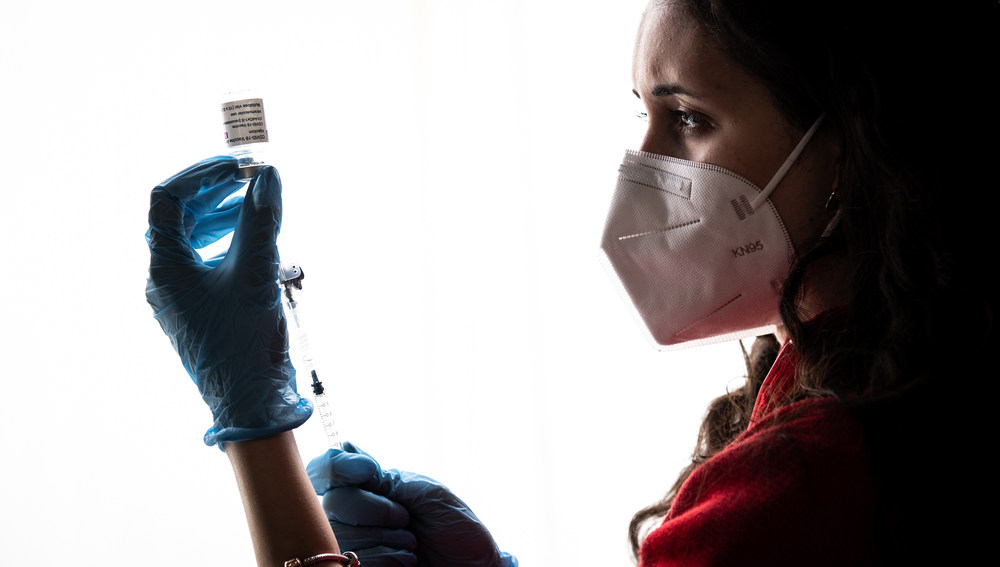 Eine Frau zieht eine Spritze auf mit dem Impfstoff gegen das Coronavirus