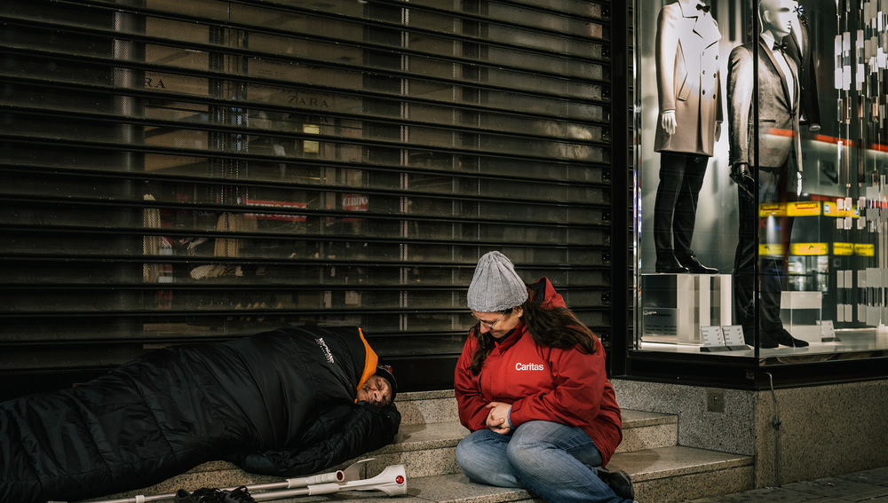 Caritas-Streetworkerin mit Obdachlosem im Winter