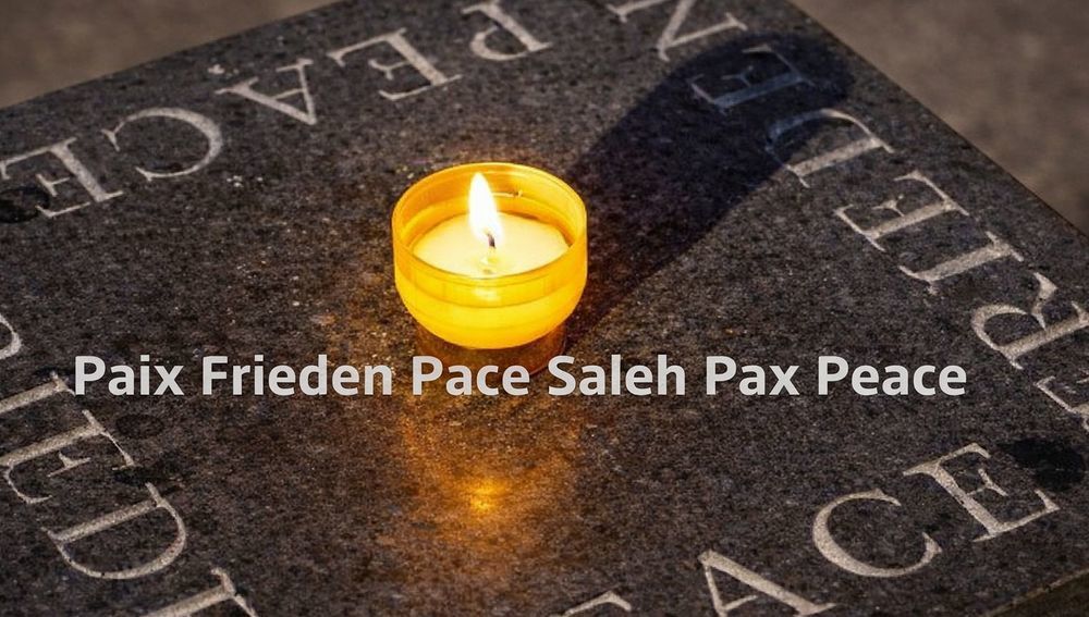 Kerze mit Aufschrift Friede in verschiedenen Sprachen