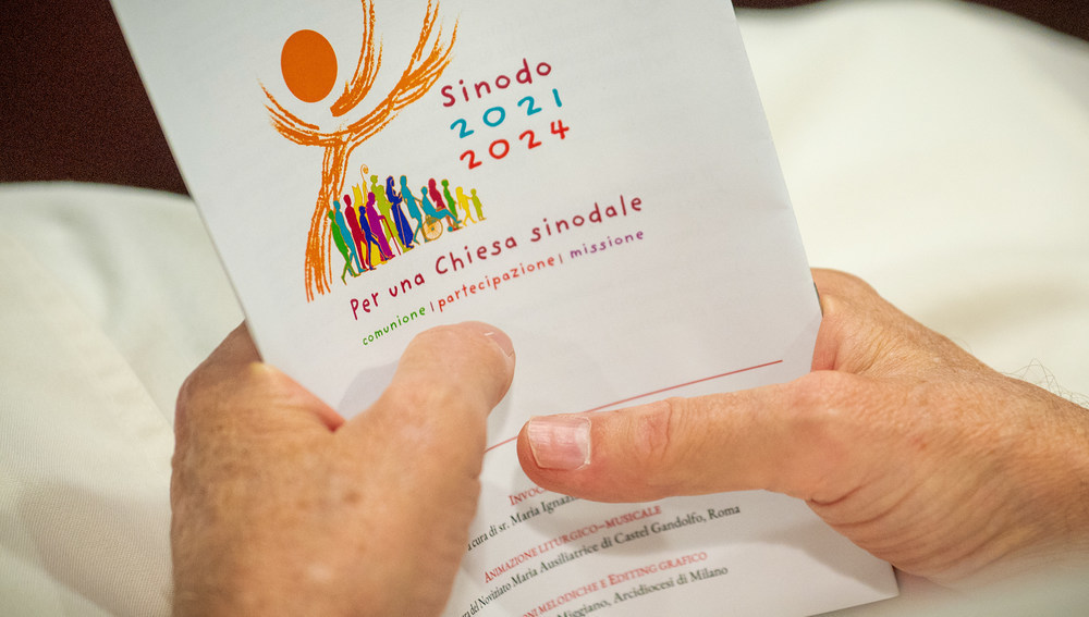 Synodenteilnehmer hält Zettel Mit Logo der Synode über Synodalität