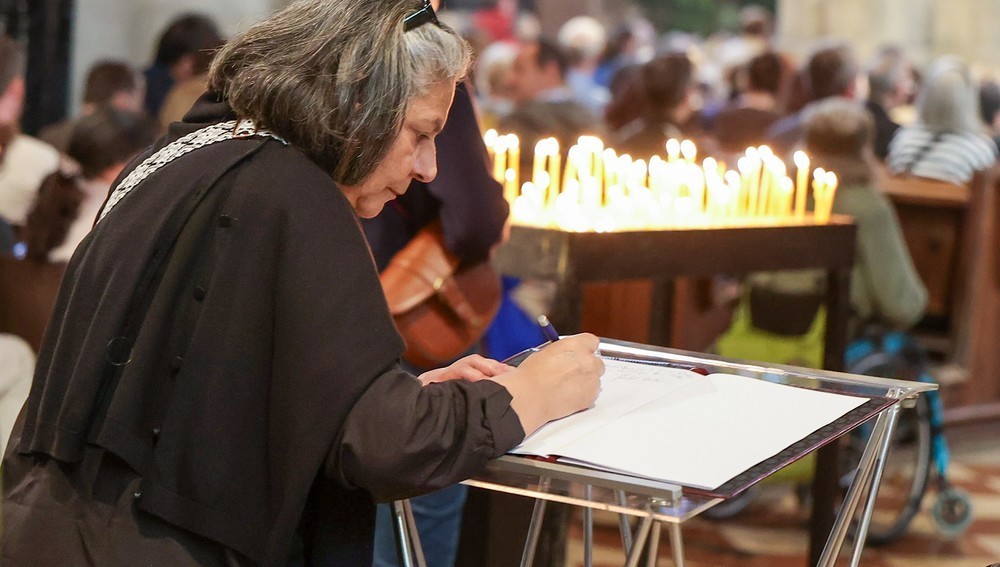 Frau trägt sich in Kondolenzbuch im Stephansdom zum Tod von Papst Franziskus ein