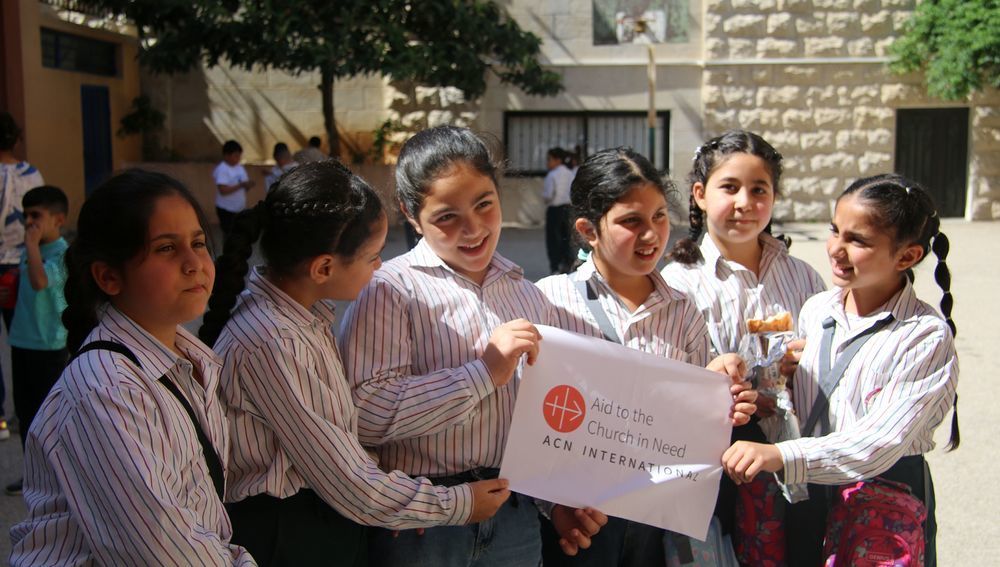 Schülerinnen der kirchlichen Schule in Debel im Libanon mit Logo von 'Kirche in Not'